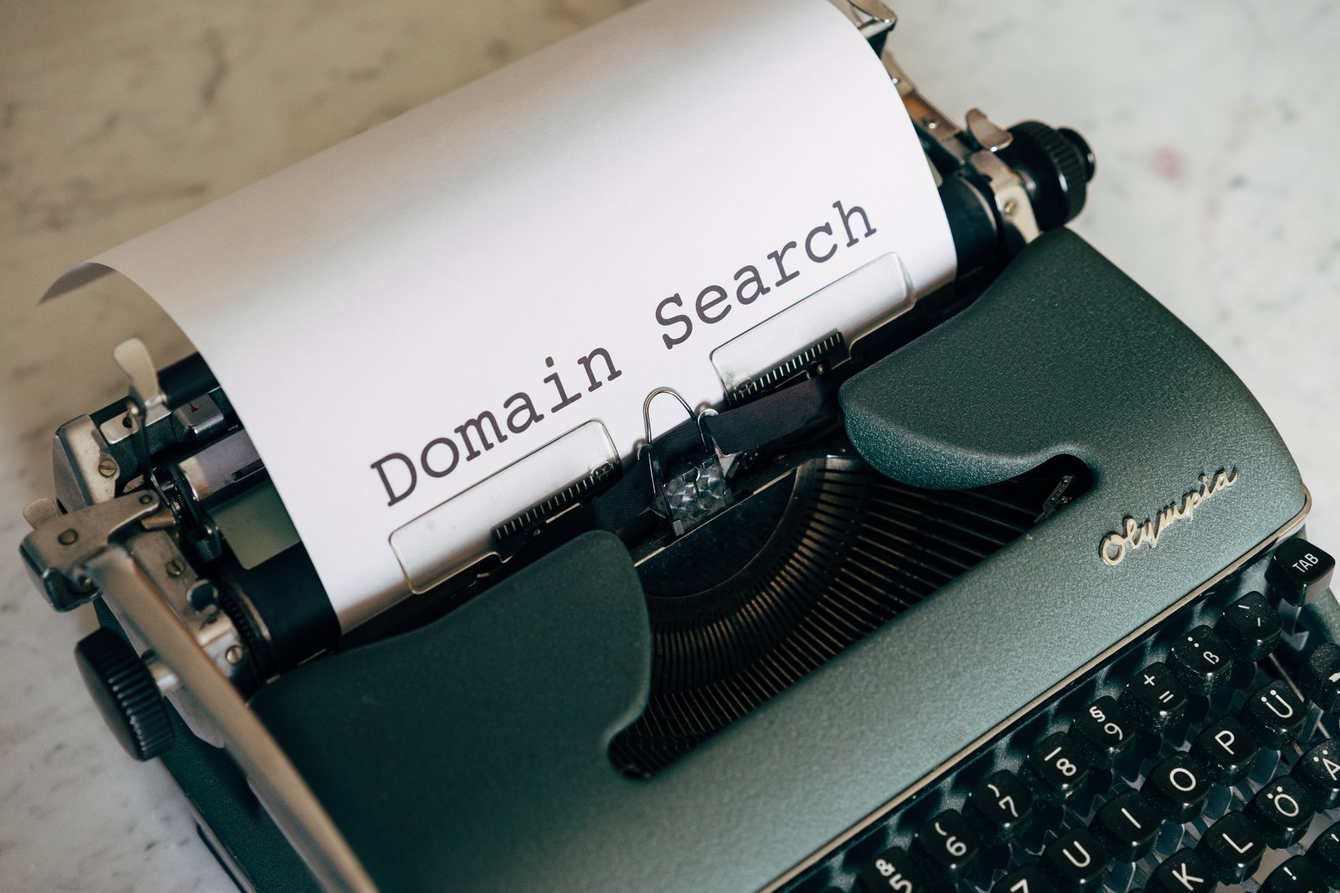 Skrivmaskin med ett papper där det står Domain Search