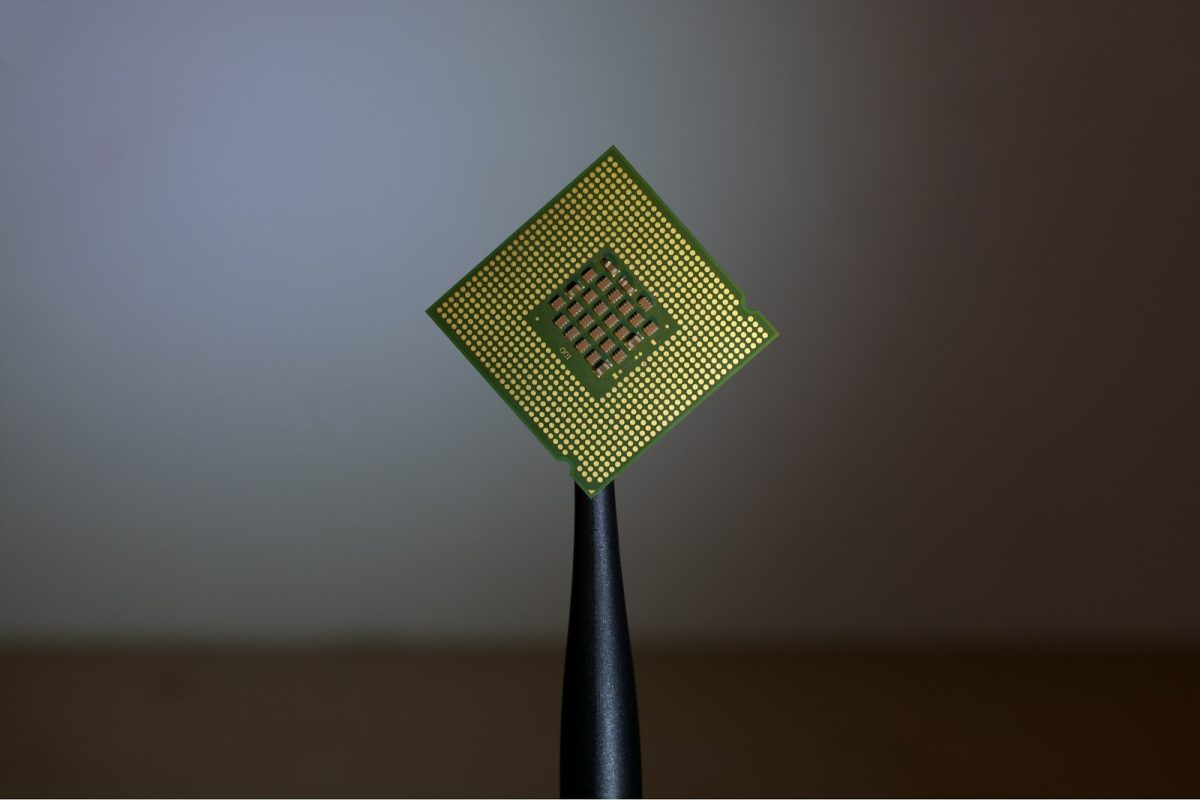 Närbild på en datorprocessor som hålls upp mot en suddig bakgrund