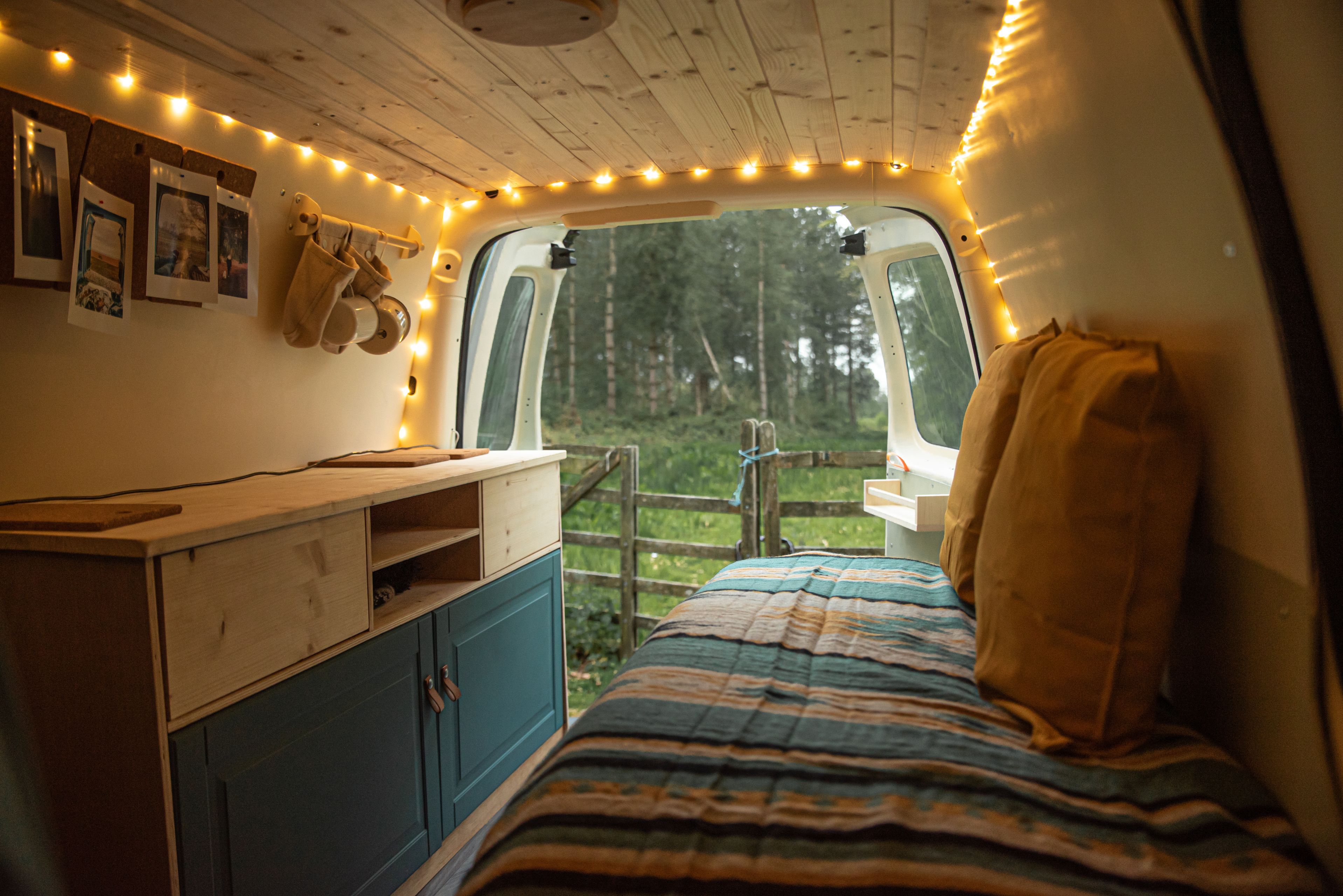 Mysig campervaninredning med bädd och pentry
