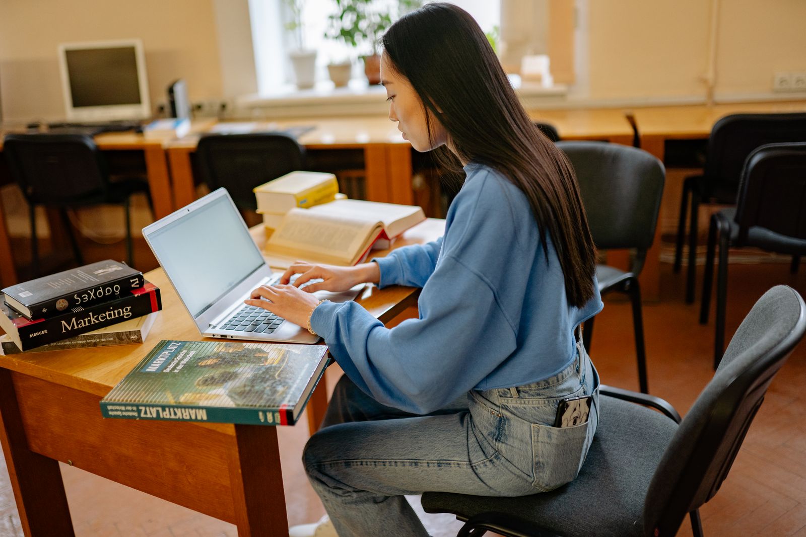 Person studerar teori vid ett skrivbord med laptop