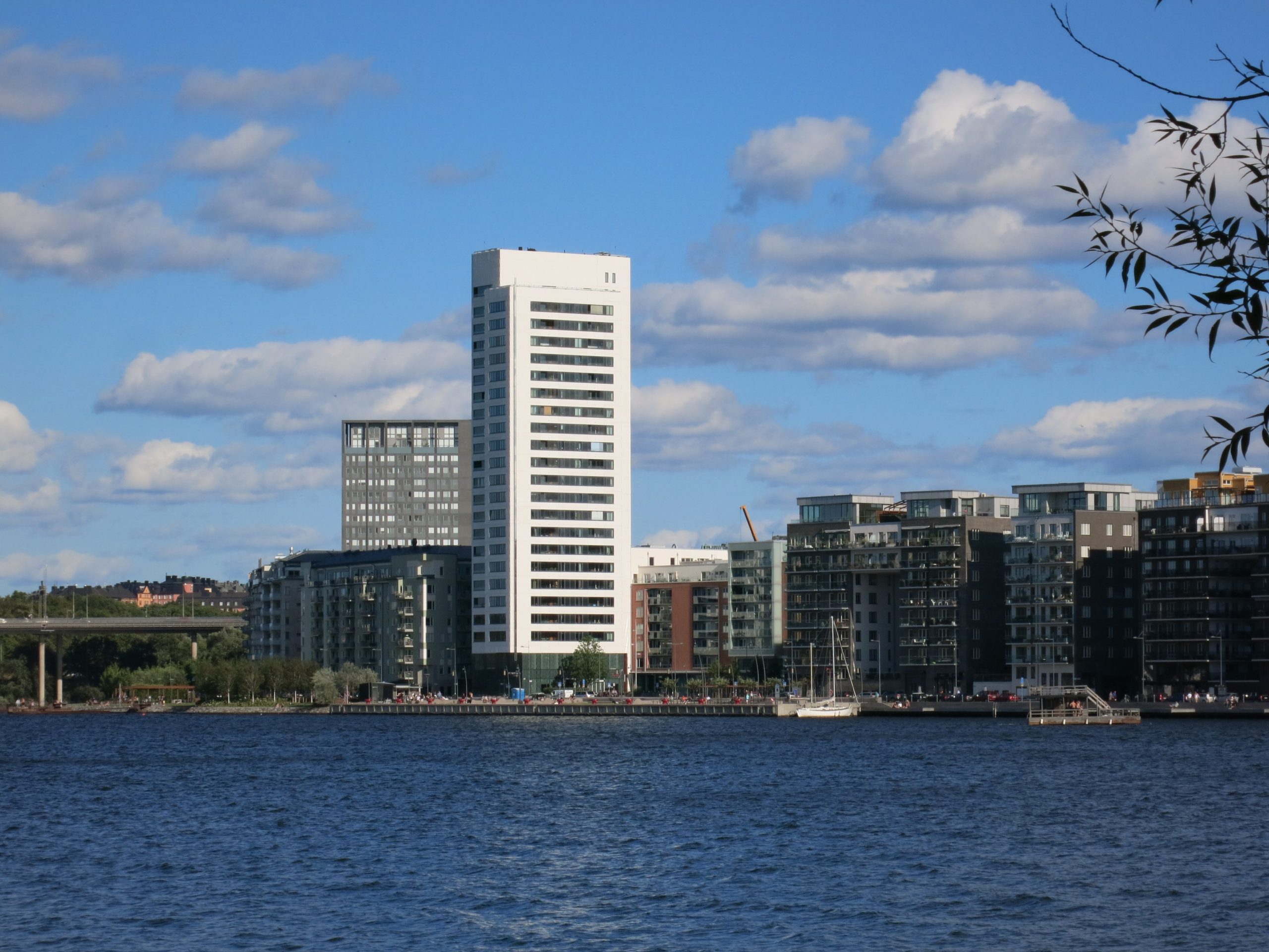 Bostadshusen vid Hornsbergs strand på nordvästra Kungsholmen sedda från Ulvsundasjön, med höghuset i kvarteret Lusten i mitten och strandpromenaden längs kajen.