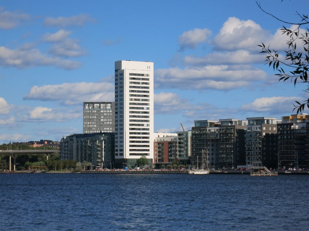 Skyline vid Hornsbergs strand med det höga bostadshuset i kvarteret Lusten sett från vattnet.