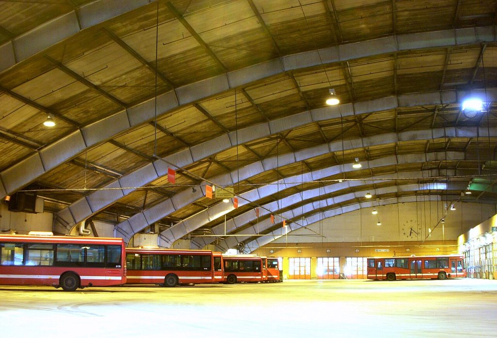 Interiör i den valvade garagehallen i Hornsbergsdepån med uppställda bussar.