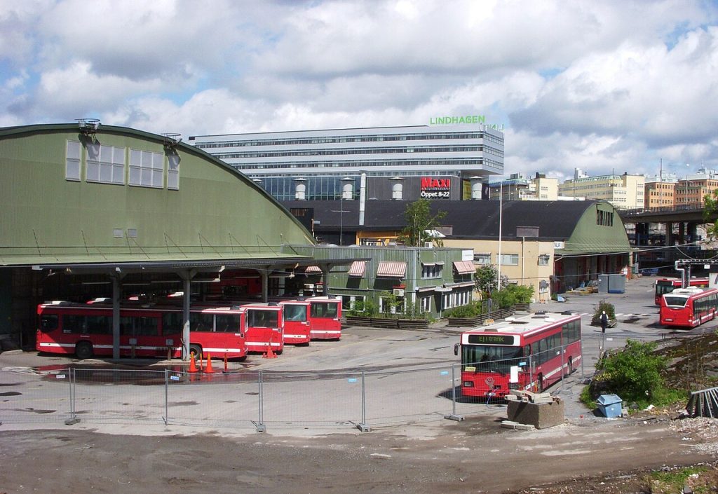 Bussdepån i Hornsberg med röda bussar uppställda framför de välvda garagehallarna.