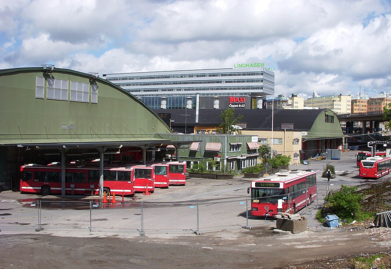 Bussdepån i Hornsberg med röda bussar uppställda framför de välvda garagehallarna.