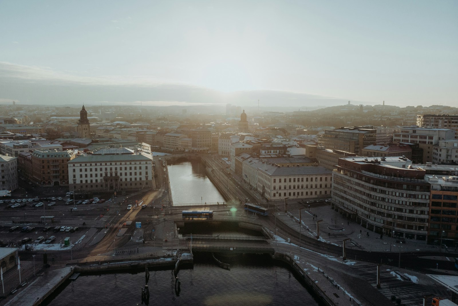Flygvy över Göteborgs kanaler och centrala kvarter i motljus.