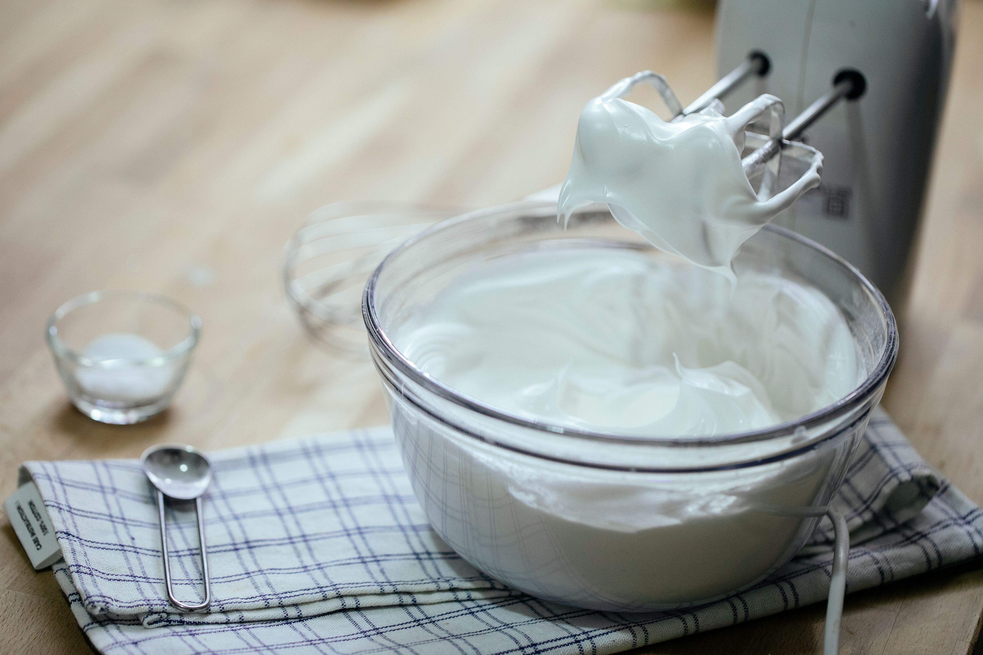 Vispad vit aquafaba med styva toppar i en glasskål