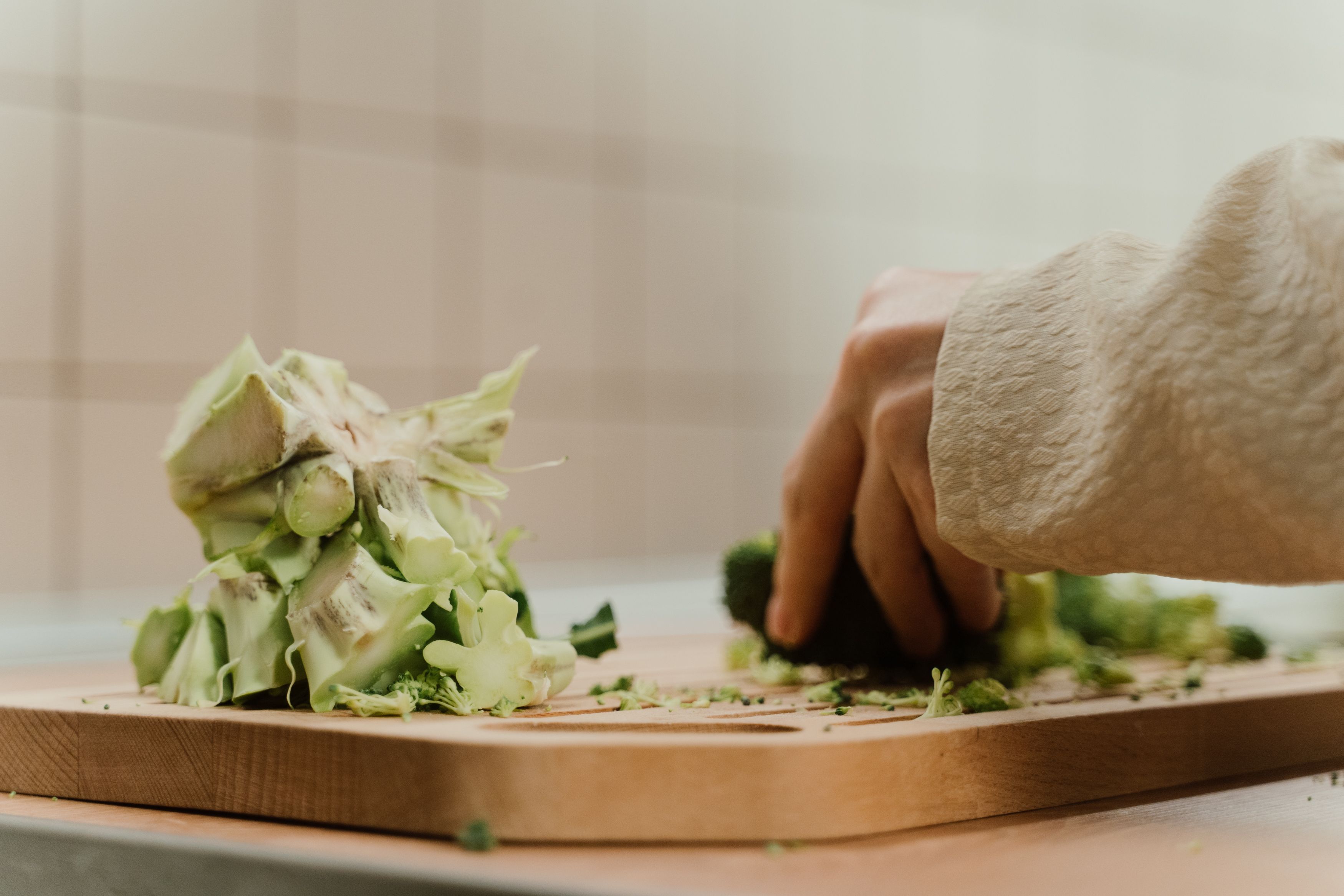 Broccolistjälk som skärs på en skärbräda av trä