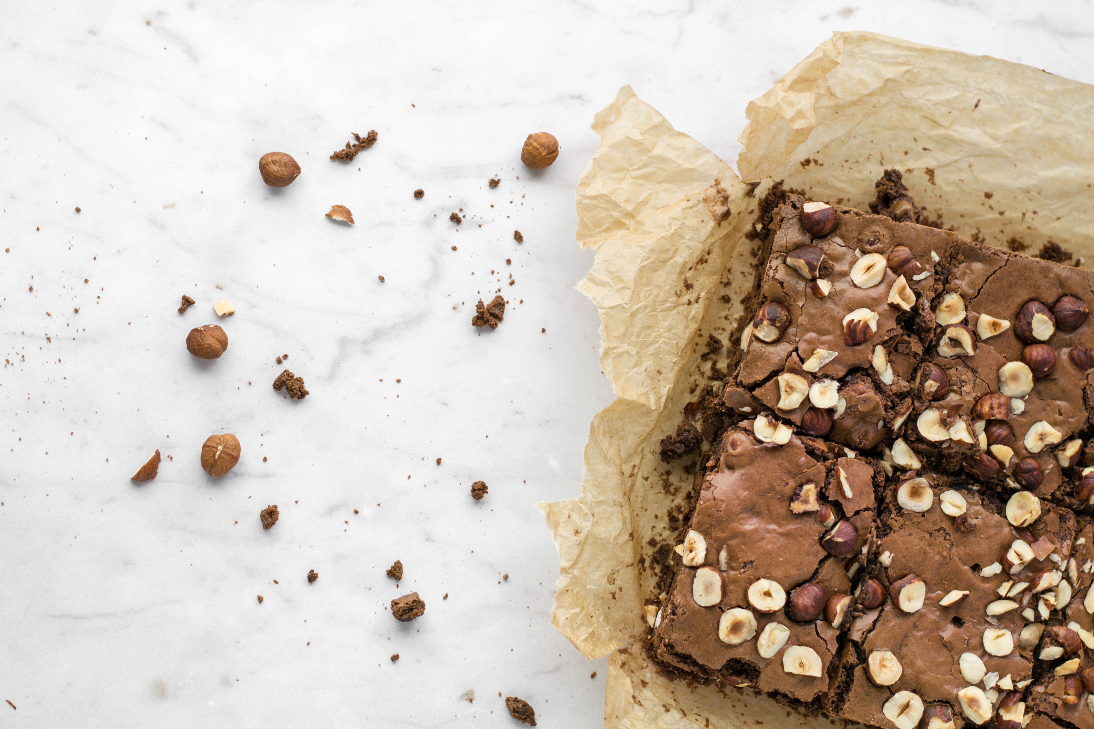 Kladdig chokladkaka i rutor toppad med rostade hasselnötter