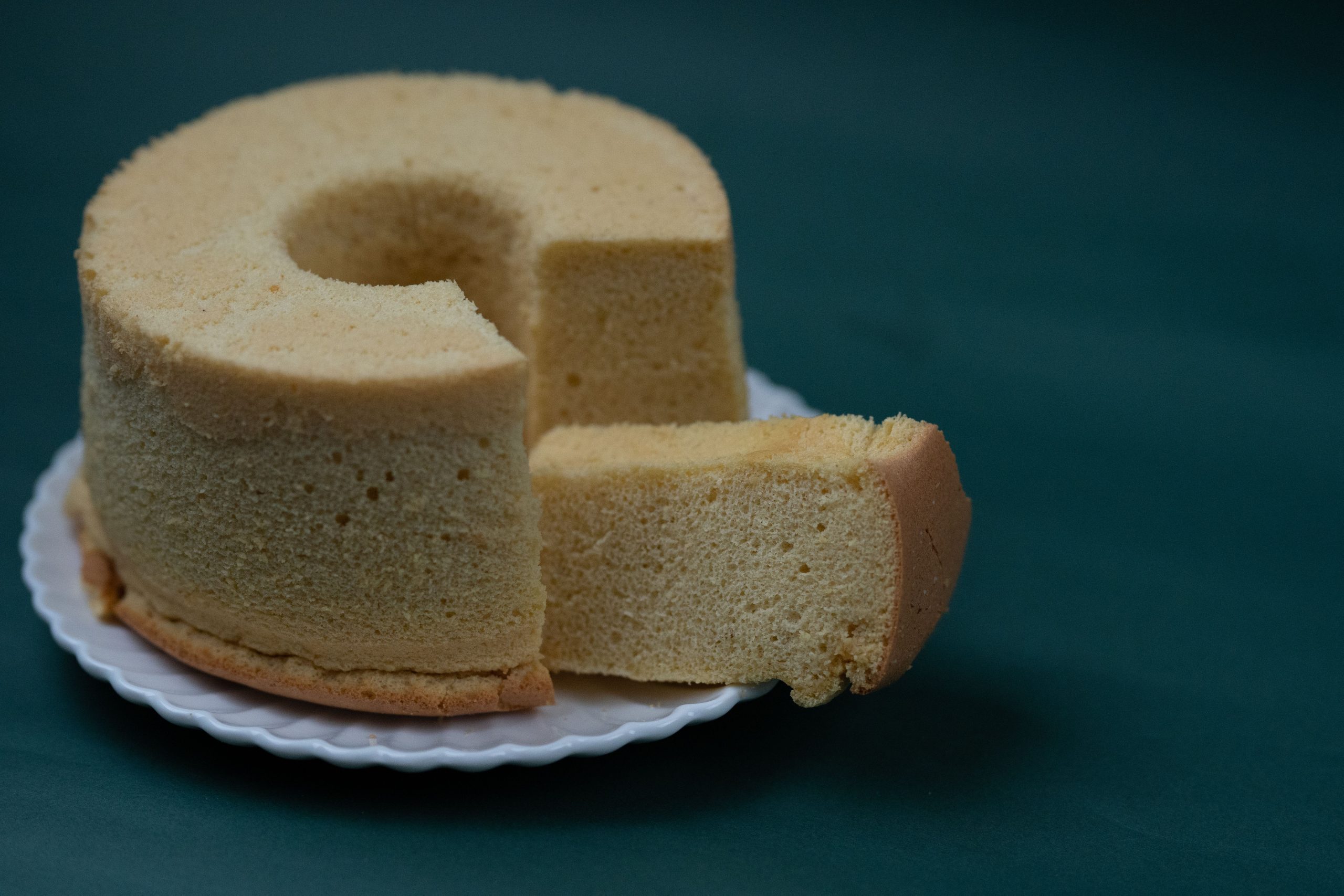 Hög, ljus sockerkaka med en uppskuren bit som visar ett fint och luftigt inkråm