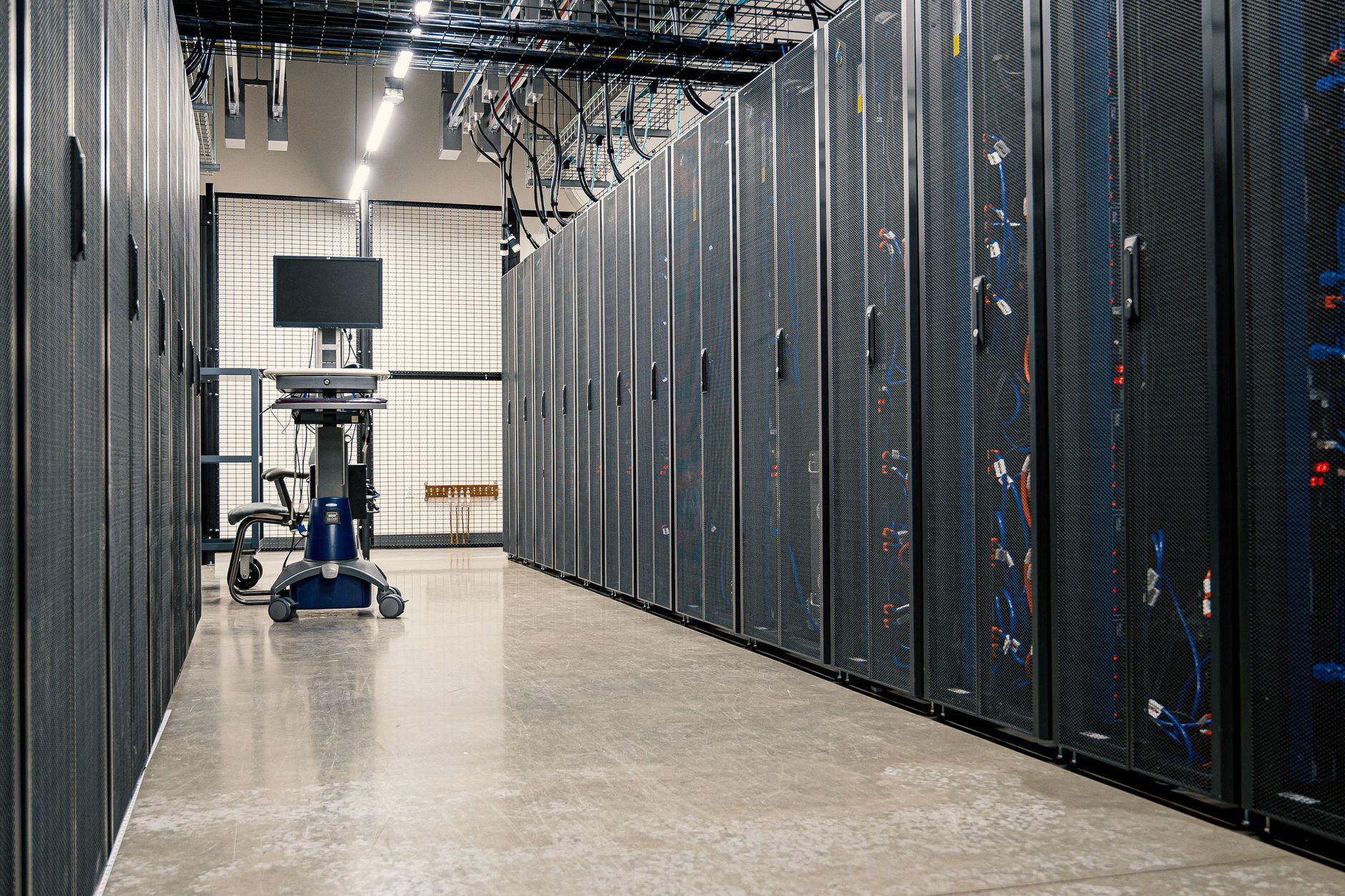 Gång mellan rader av svarta serverrack i en datorhall