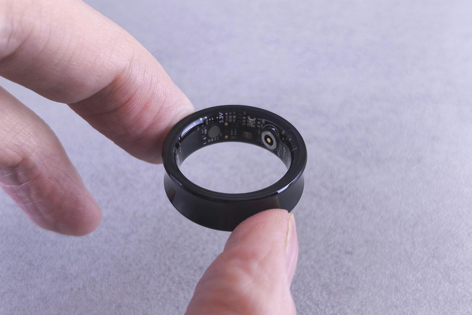 Smart ring held between fingertips