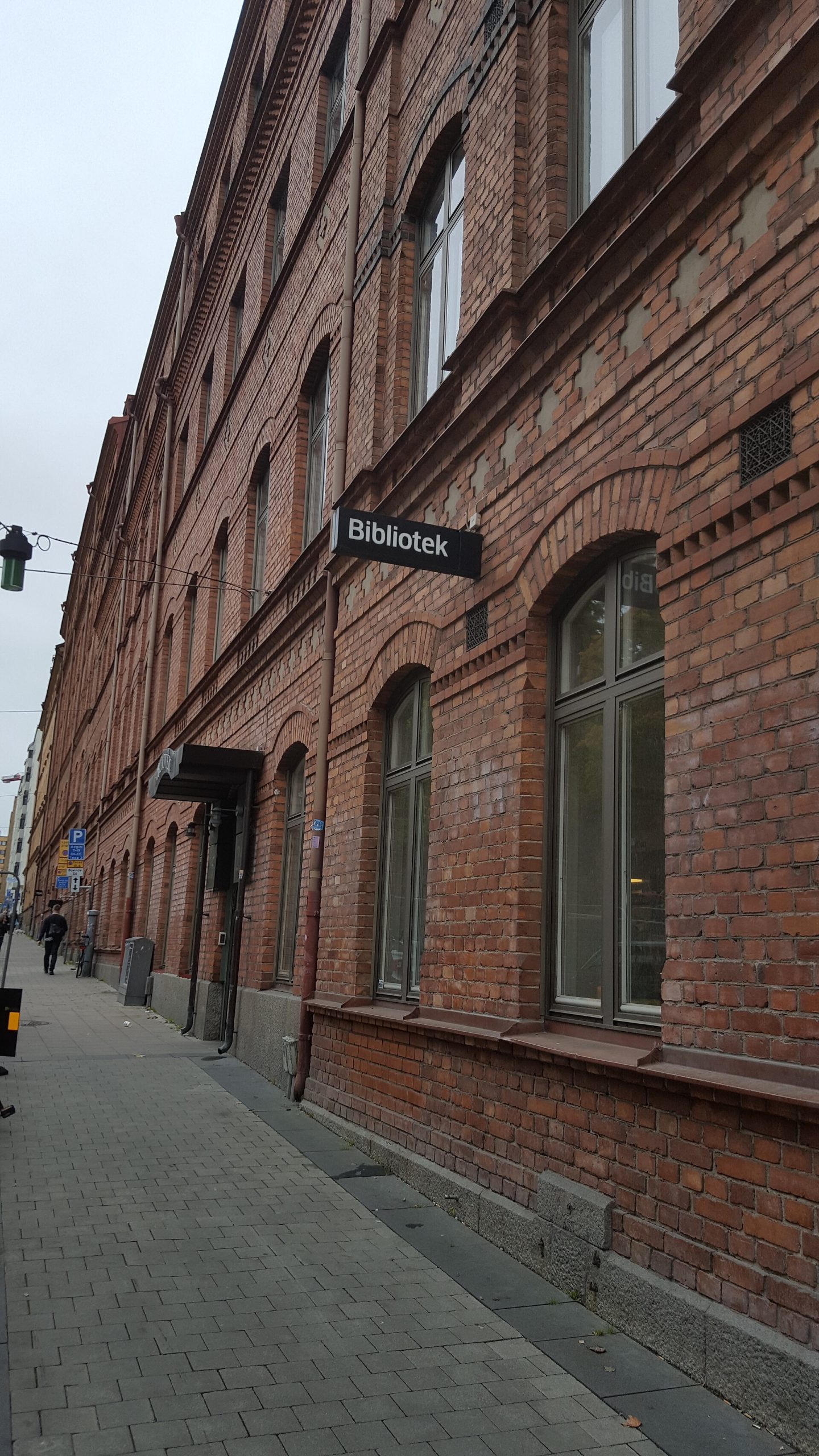 Röd tegelbyggnad med skylten Bibliotek, Hornstulls bibliotek i den gamla skofabriken