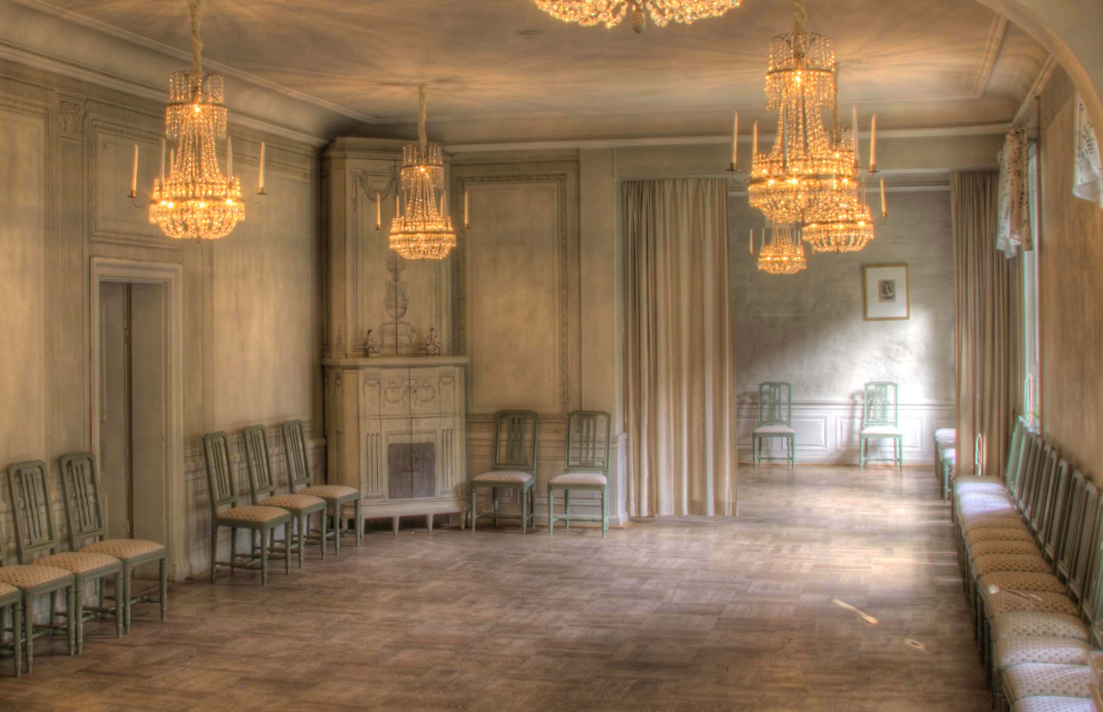 Kristinasalen på Kristinehovs malmgård, en ljus 1700-talssal med kristallkronor, gustavianska stolar längs väggarna och parkettgolv.