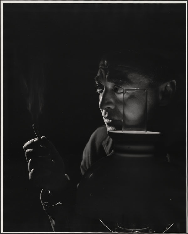 Svartvitt porträtt av Peter Lorre med en cigarett, belyst av en lampa