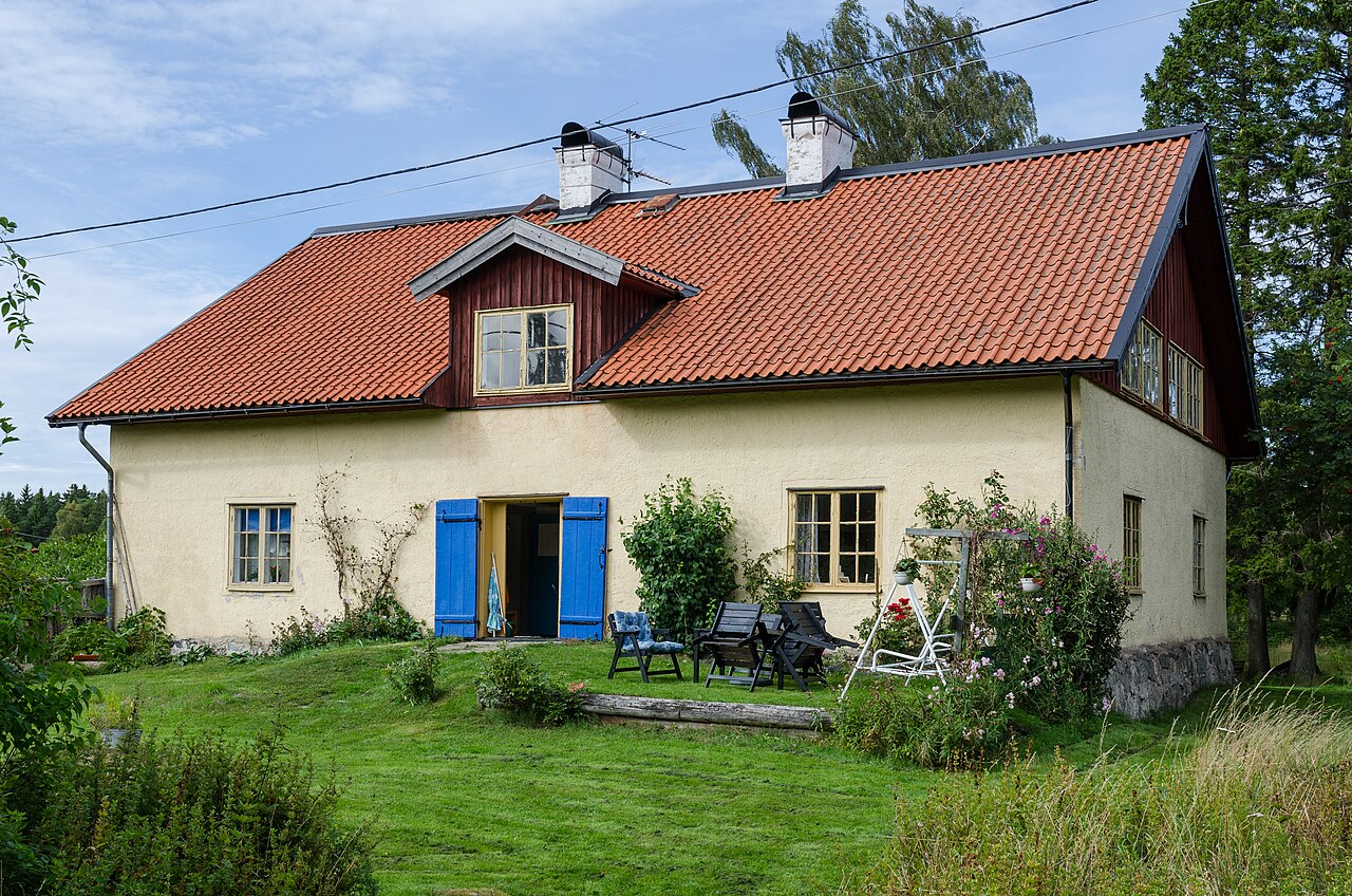 Klassiskt gult trähus med röda detaljer på Utö