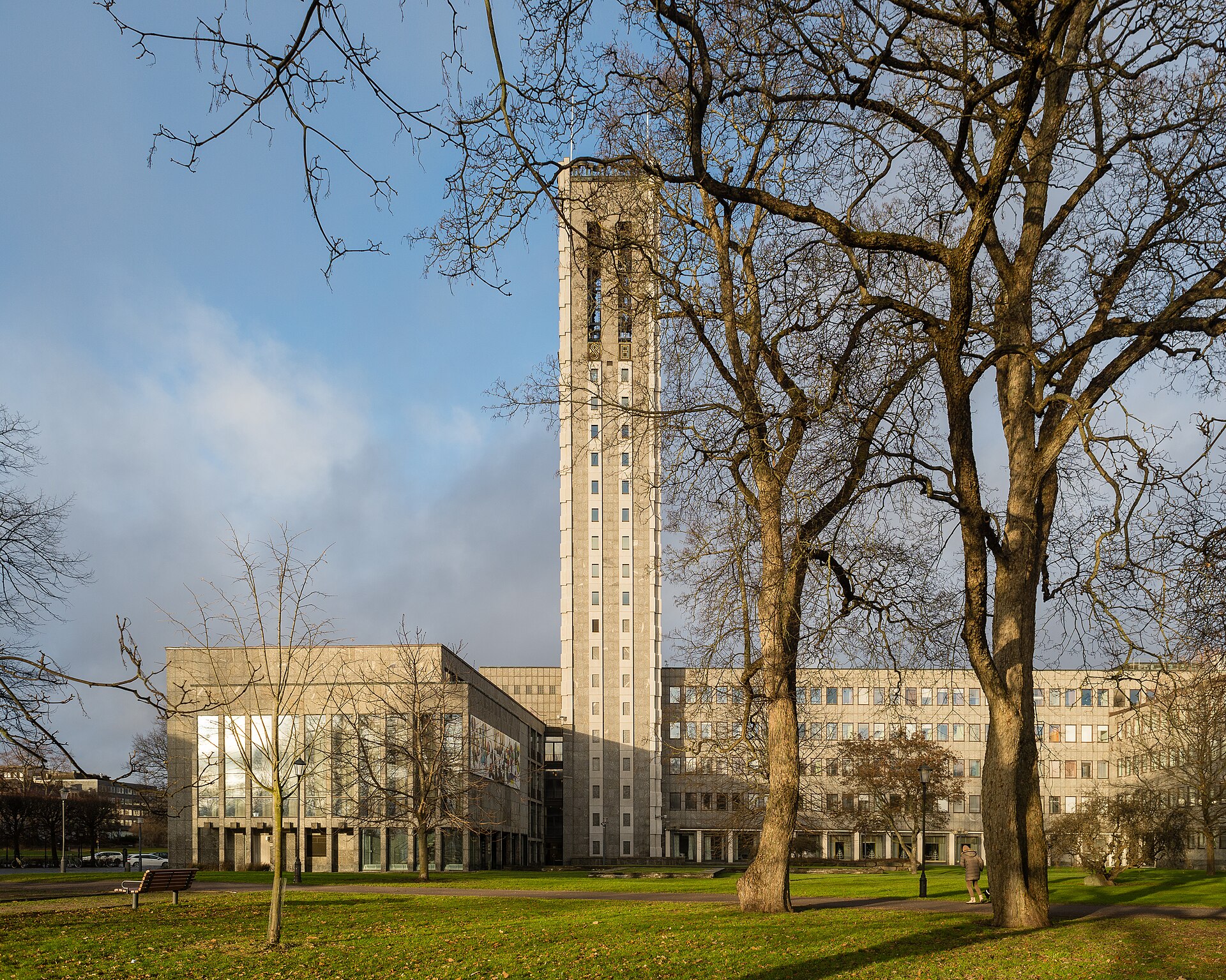 Västerås stadshus med klocktornet, sett från parken med kala träd i vinterljus