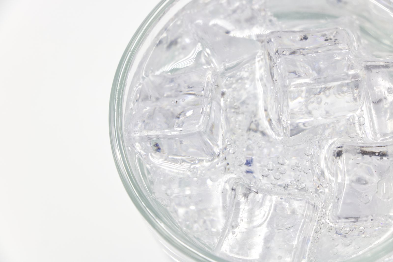 Glas med kolsyrat vatten och iskuber