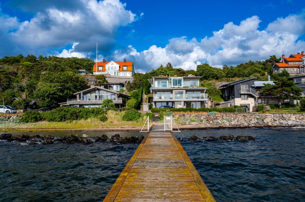 Villor vid havet i Göteborgs skärgård, sedda från en brygga.