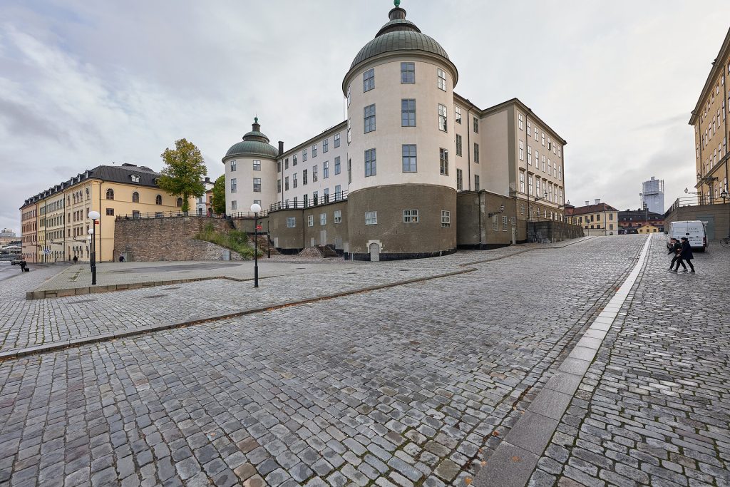 Wrangelska palatset på Riddarholmen i Stockholm, säte för Svea hovrätt, med två runda torn och gröna kupoltak vid en kullerstensgata.