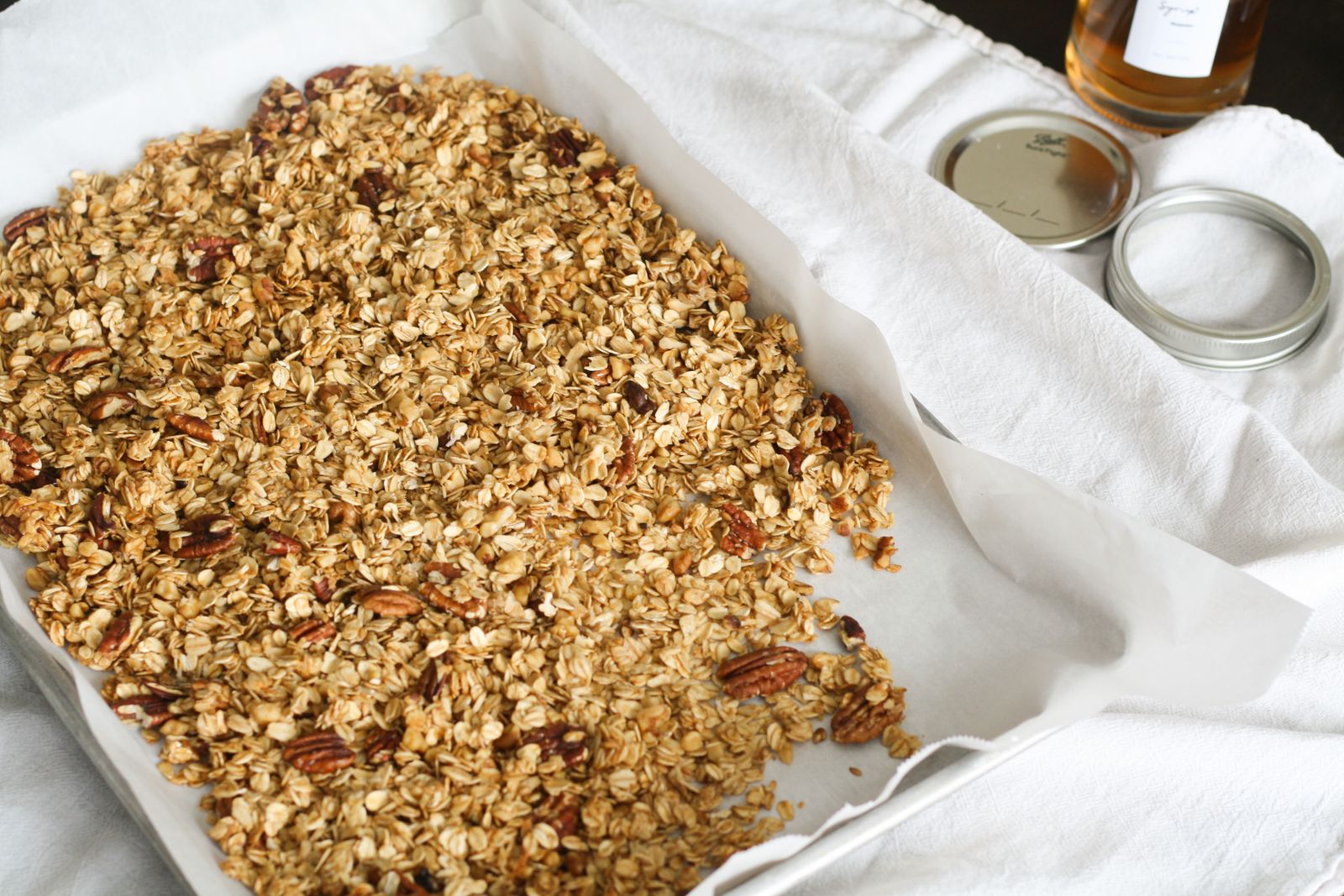 Gyllene knaprig granola med pekannötter på en plåt med bakplåtspapper