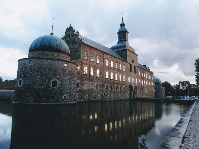 Vadstena slott vid skymning speglat i vallgraven