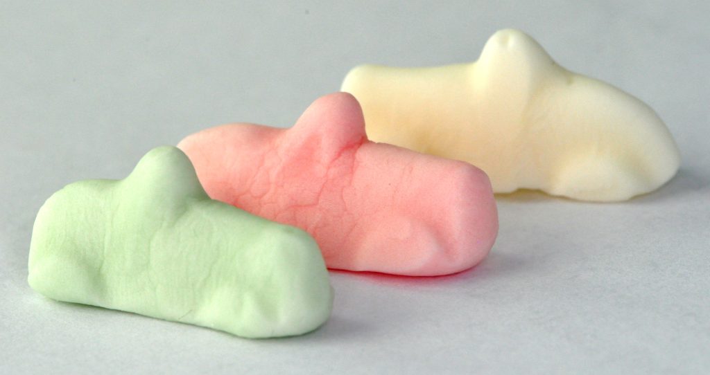 Tre Ahlgrens bilar i original, en grön, en rosa och en vit, i närbild
