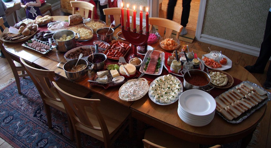 Traditional Swedish julbord laid out on a wooden table at home