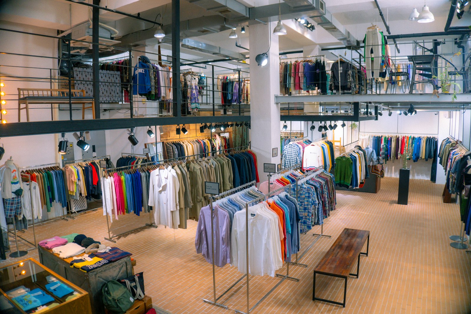 Klädbutik med fulla klädställningar i två plan