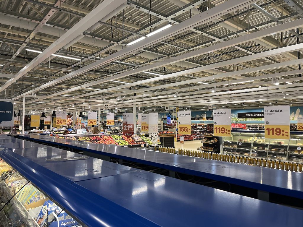 Svensk stormarknad med kyldiskar, fruktavdelning och prisskyltar