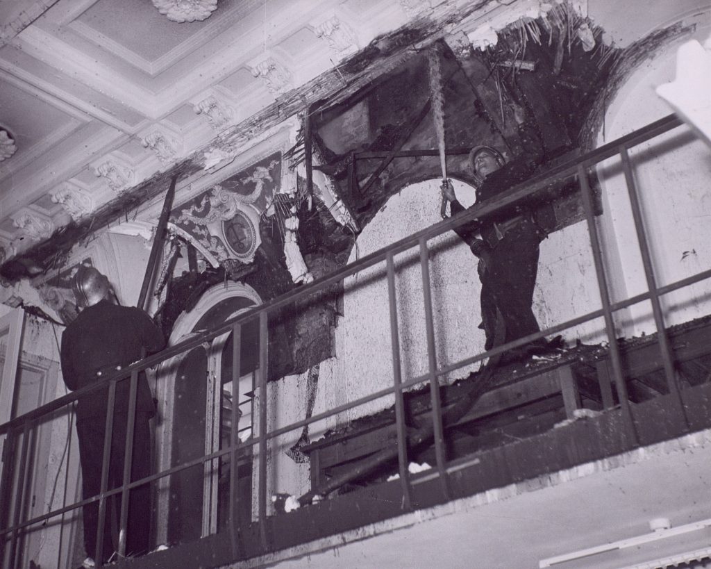 Brandmän river ut skadade tak- och väggpartier inne i telefonstationen vid Malmskillnadsgatan efter branden 1952