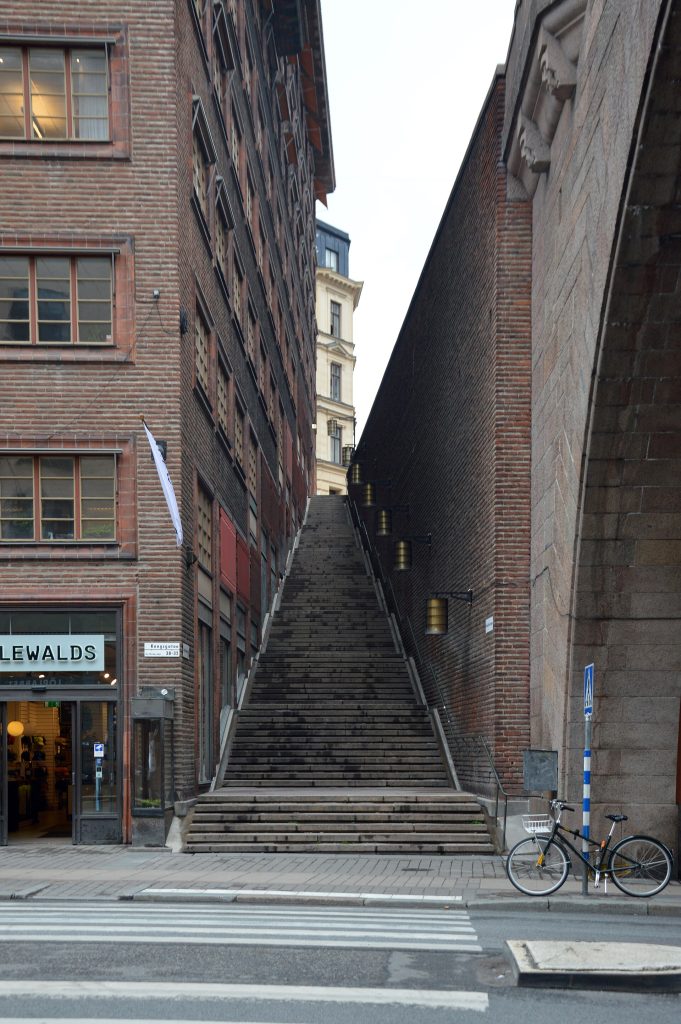 Malmskillnadstrappan sedd från Kungsgatan, en lång och smal granittrappa med vilplan mellan Centrumhusets tegelfasad till vänster och Malmskillnadsbrons tegelmur till höger