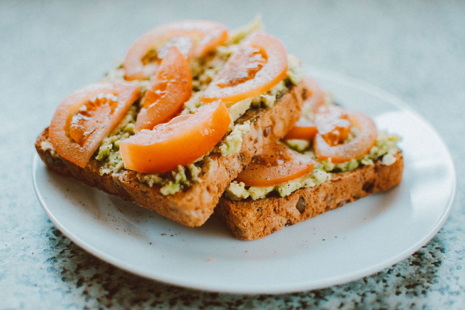 Smörgås på fullkornsbröd toppad med avokado och tomat