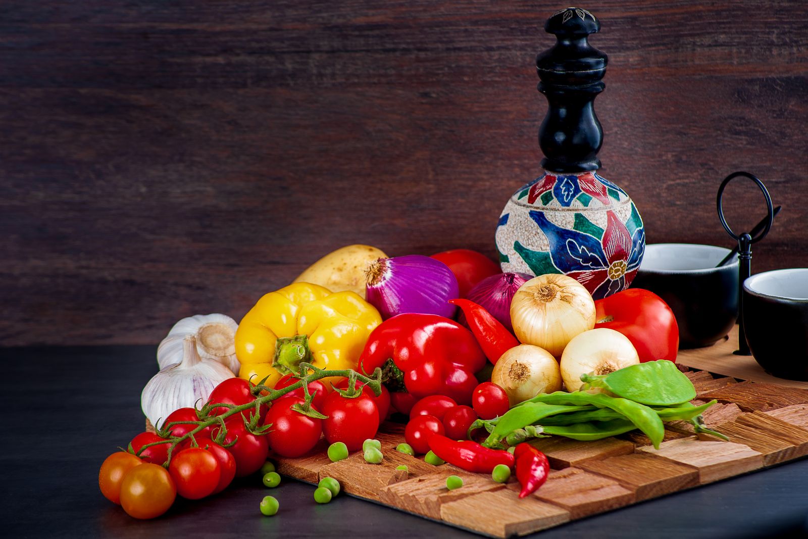 Färska färgglada grönsaker: tomater, paprika och lök på ett skärbräde