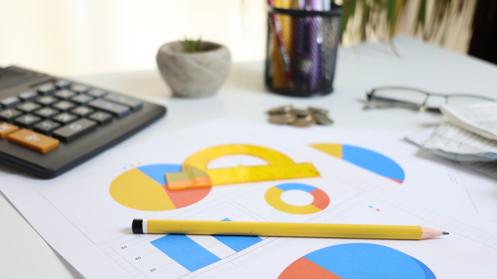 Miniräknare och färgglatt cirkeldiagram på ett skrivbord