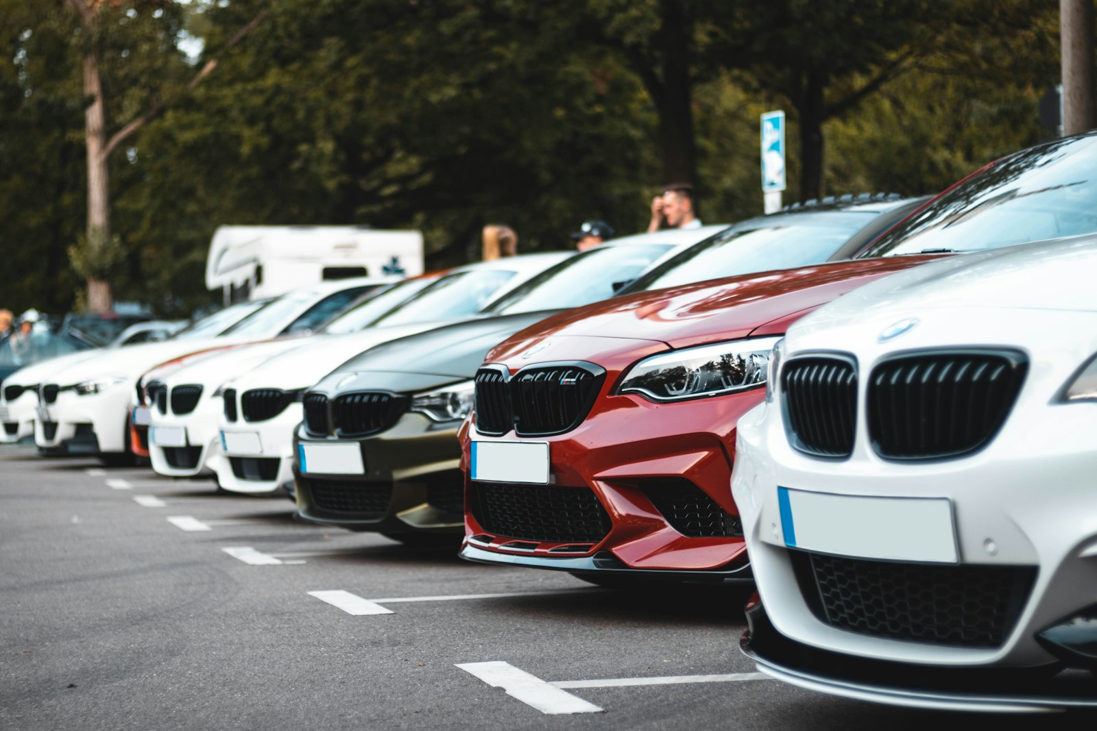 Rad av parkerade BMW-bilar sedda snett framifrån på en parkering