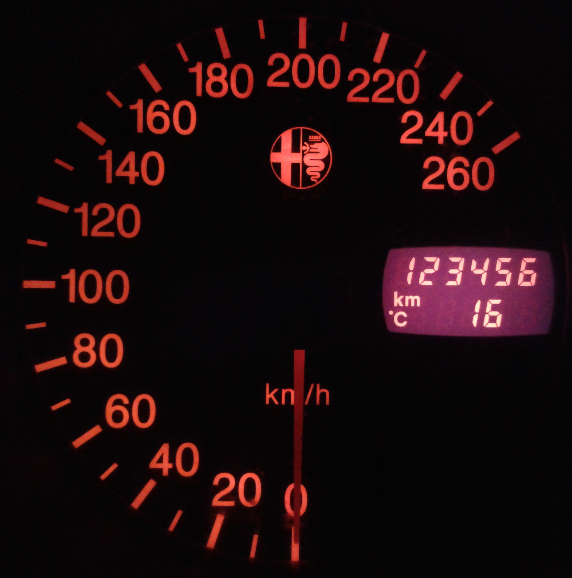 Hastighetsmätare i en Alfa Romeo som visar mätarställningen 123 456 kilometer