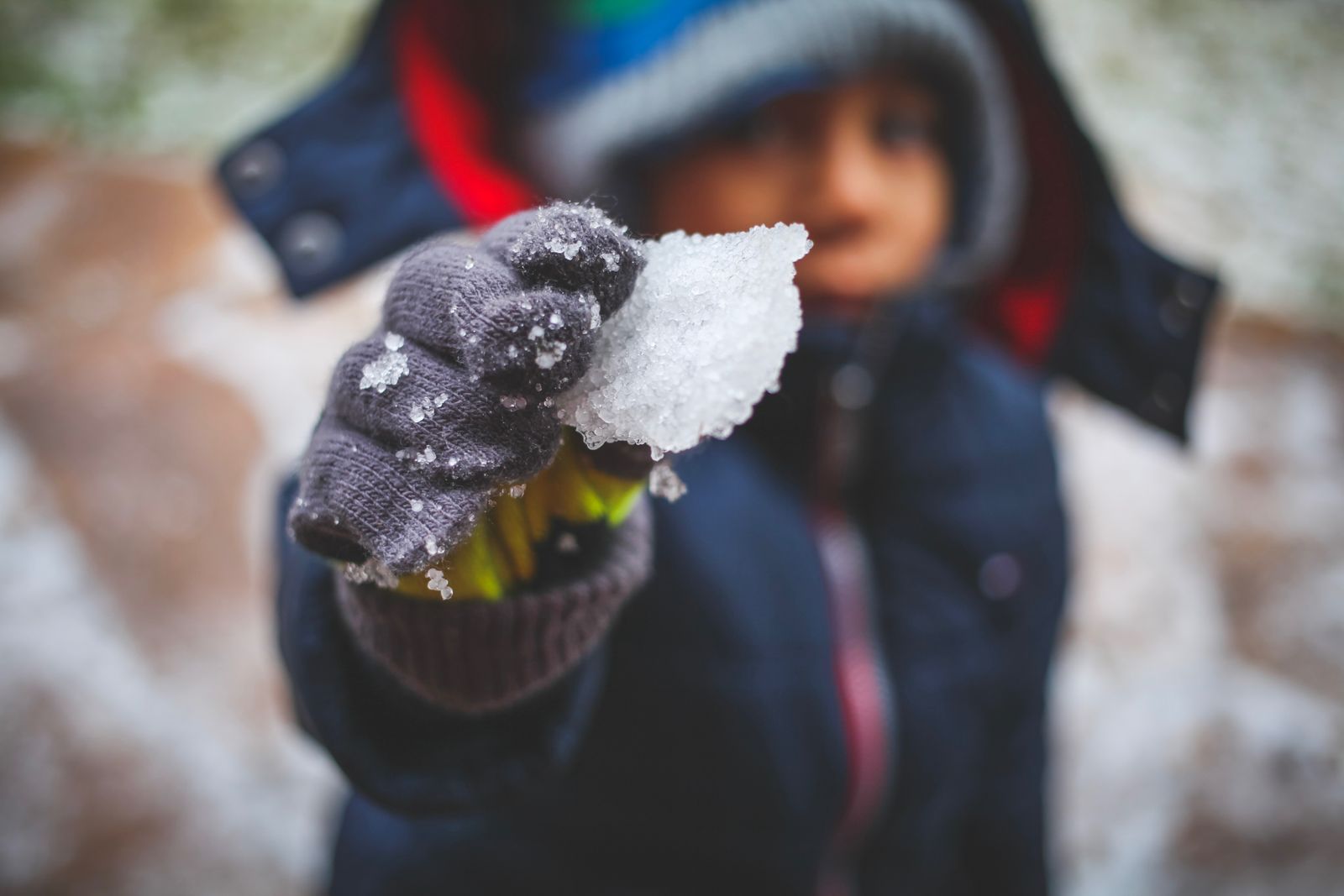 A child playing outdoors in the snow in winter