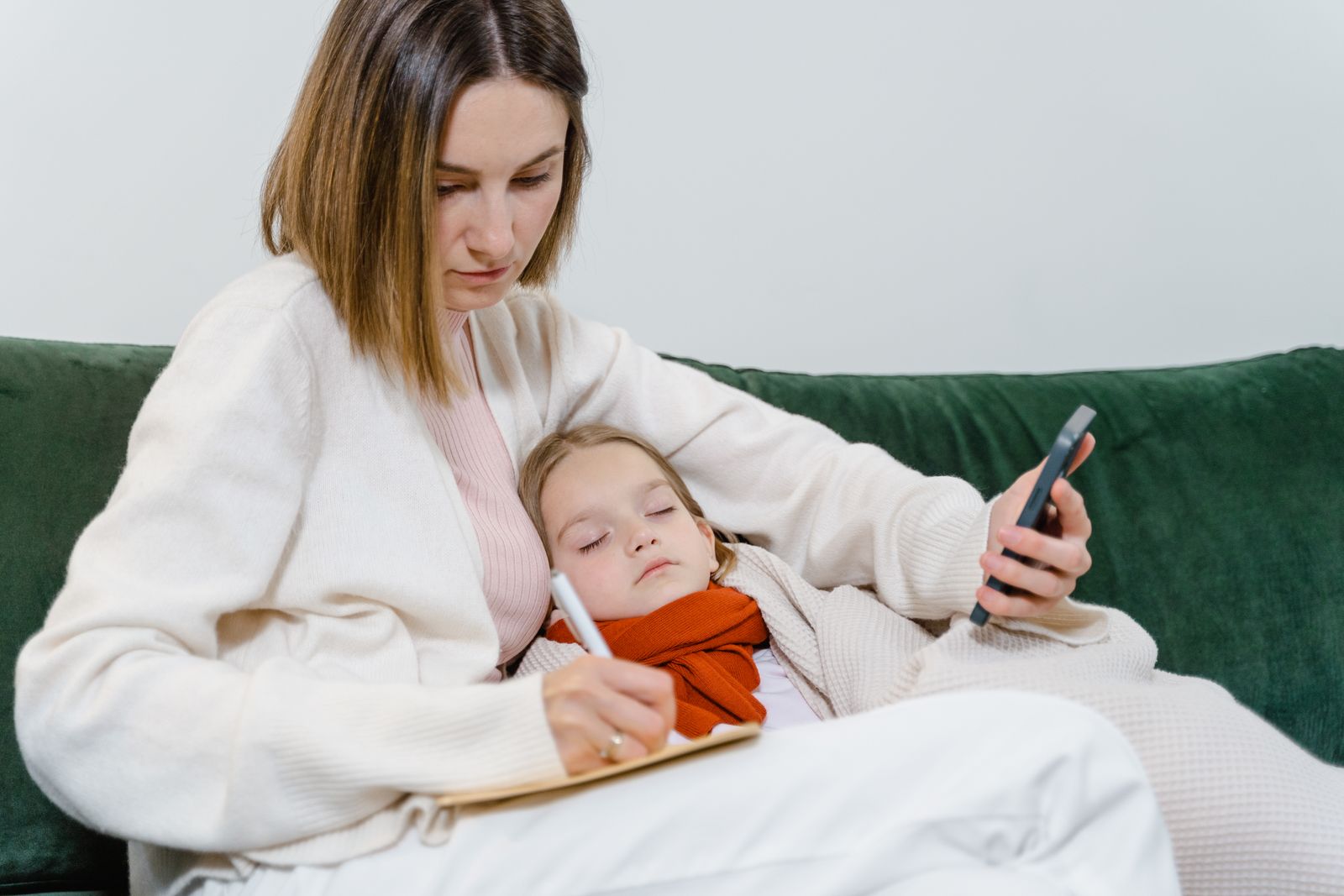 A parent holding a baby while checking healthcare information
