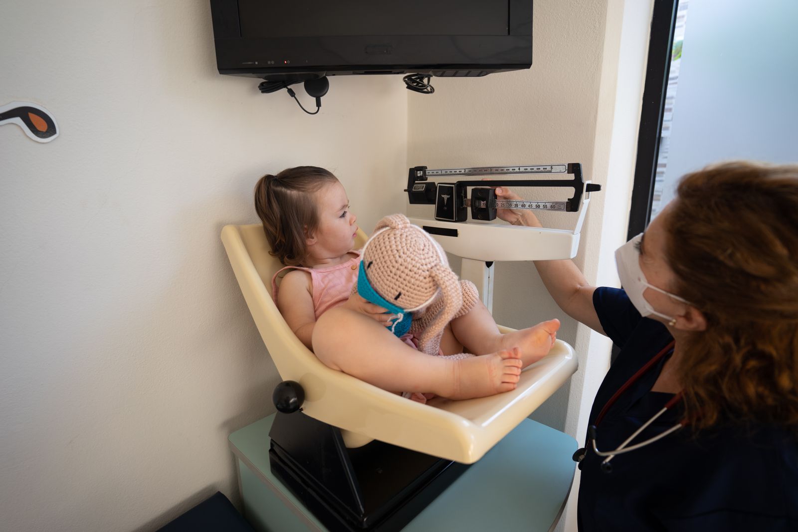 A nurse weighing a baby at a health centre