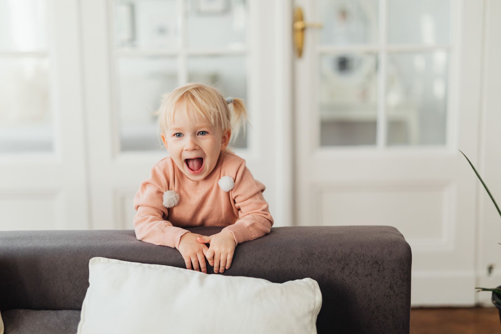 A toddler exploring a bright living room at home