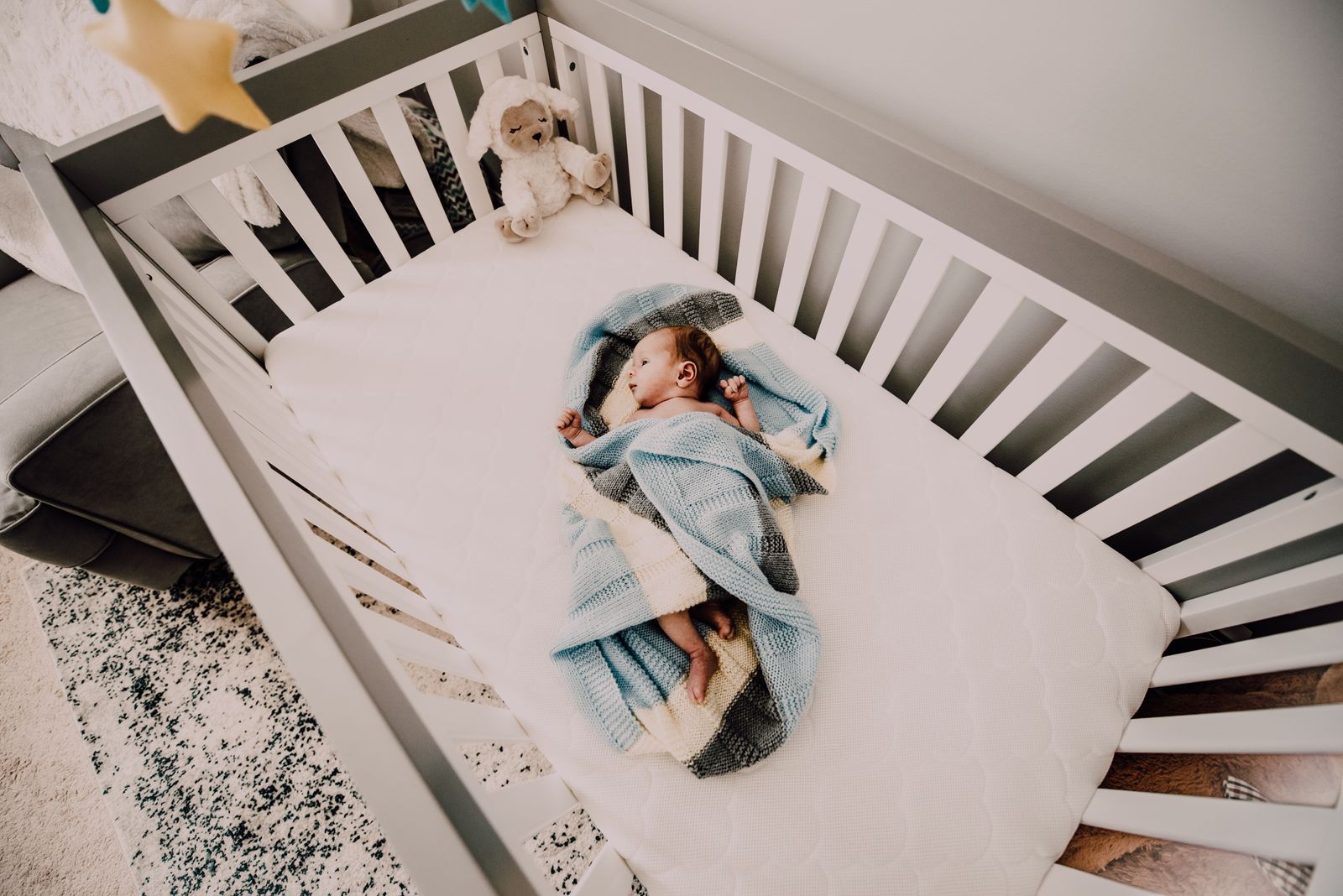 A baby sleeping on its back in a cot, the position recommended for safe infant sleep