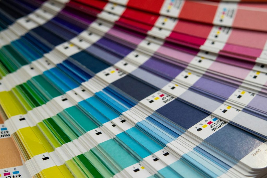Uppslagen Pantone-solfjäder med färgremsor märkta med CP-koder och CMYK-värden
