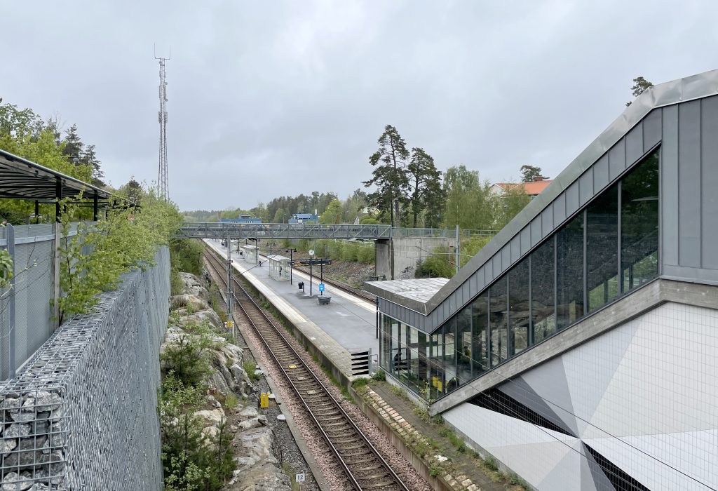 Ösmo pendeltågsstation med plattform och Nynäsbanan genom bergsskärningen