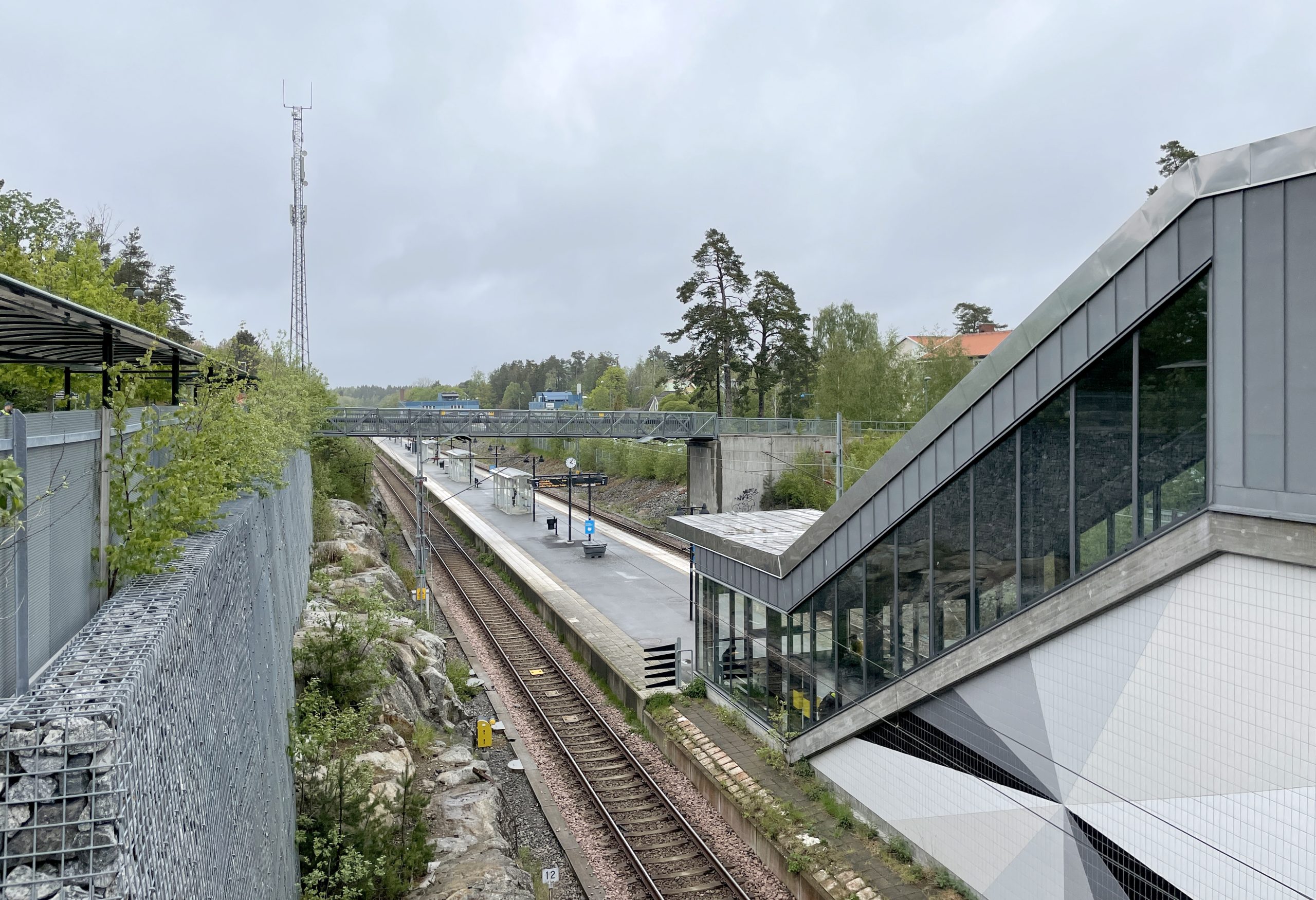 Ösmo pendeltågsstation med plattform och Nynäsbanan genom bergsskärningen