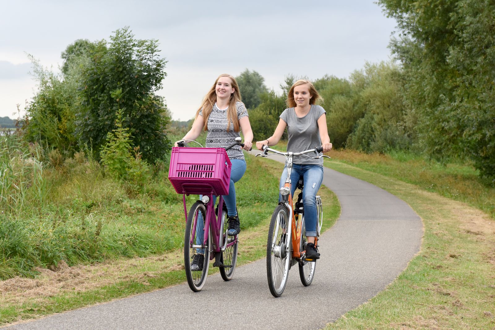 Tva barn cyklar pa en cykelvag en sommardag