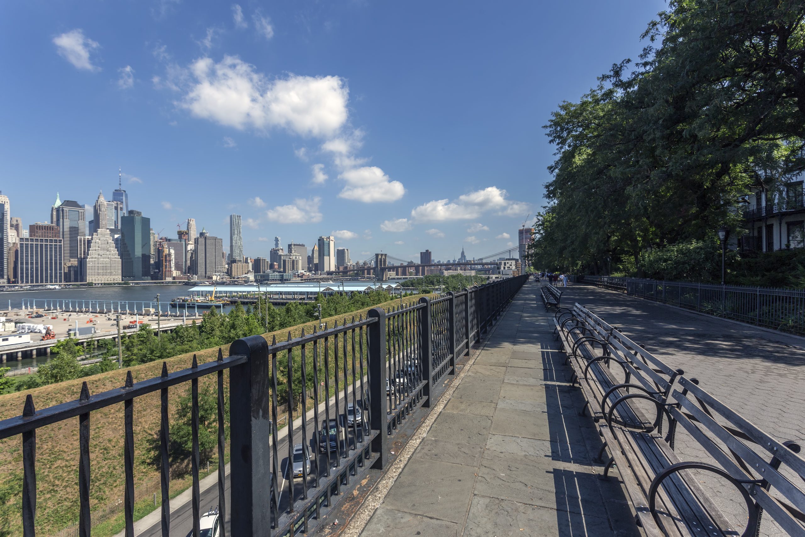 Brooklyn Heights Promenade med bänkar, räcke och Manhattans skyline