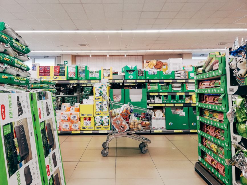 Kundvagn i en matbutik med välfyllda hyllor