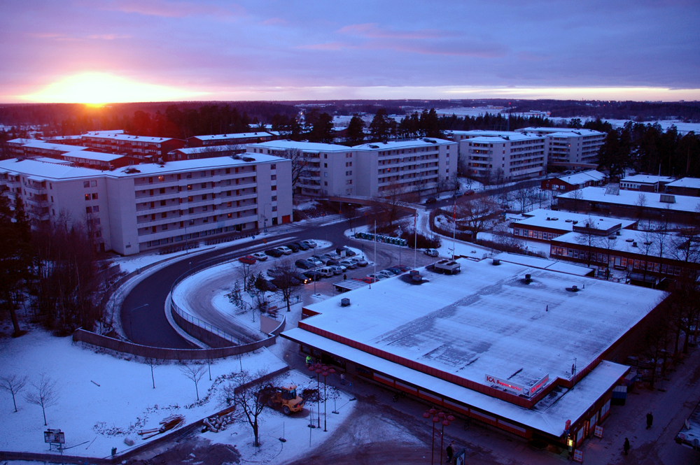 Vinterkväll över Akalla med bostadslängor längs Mariehamnsgatan och solnedgång i horisonten