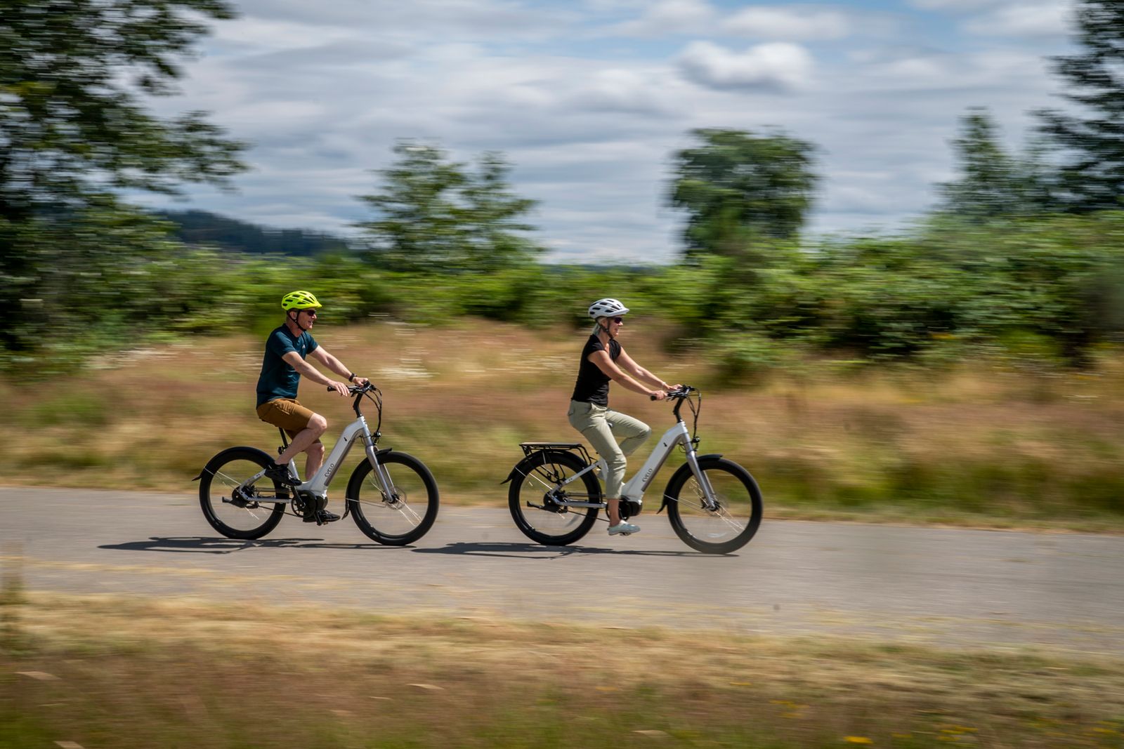 Två personer cyklar elcykel på en väg